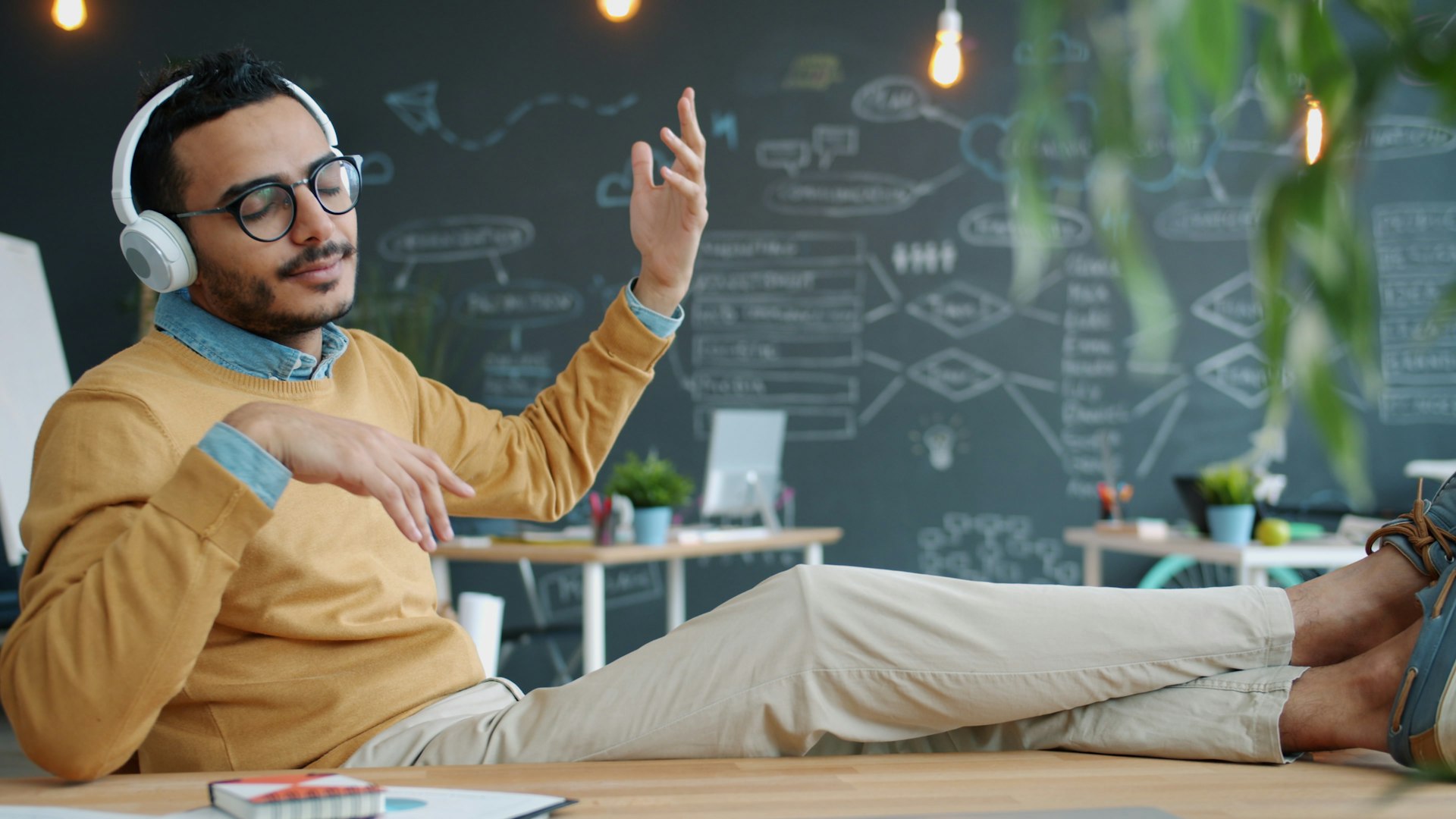 Man wearing headphones enjoys music in office.